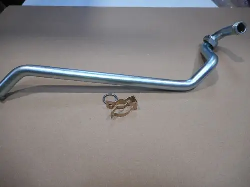 Vorlaufrohr von Remeha mit O-Ring und Clip, auf einer braunen Fläche liegend, geeignet für Heizsysteme oder ähnliche Anwendungen.